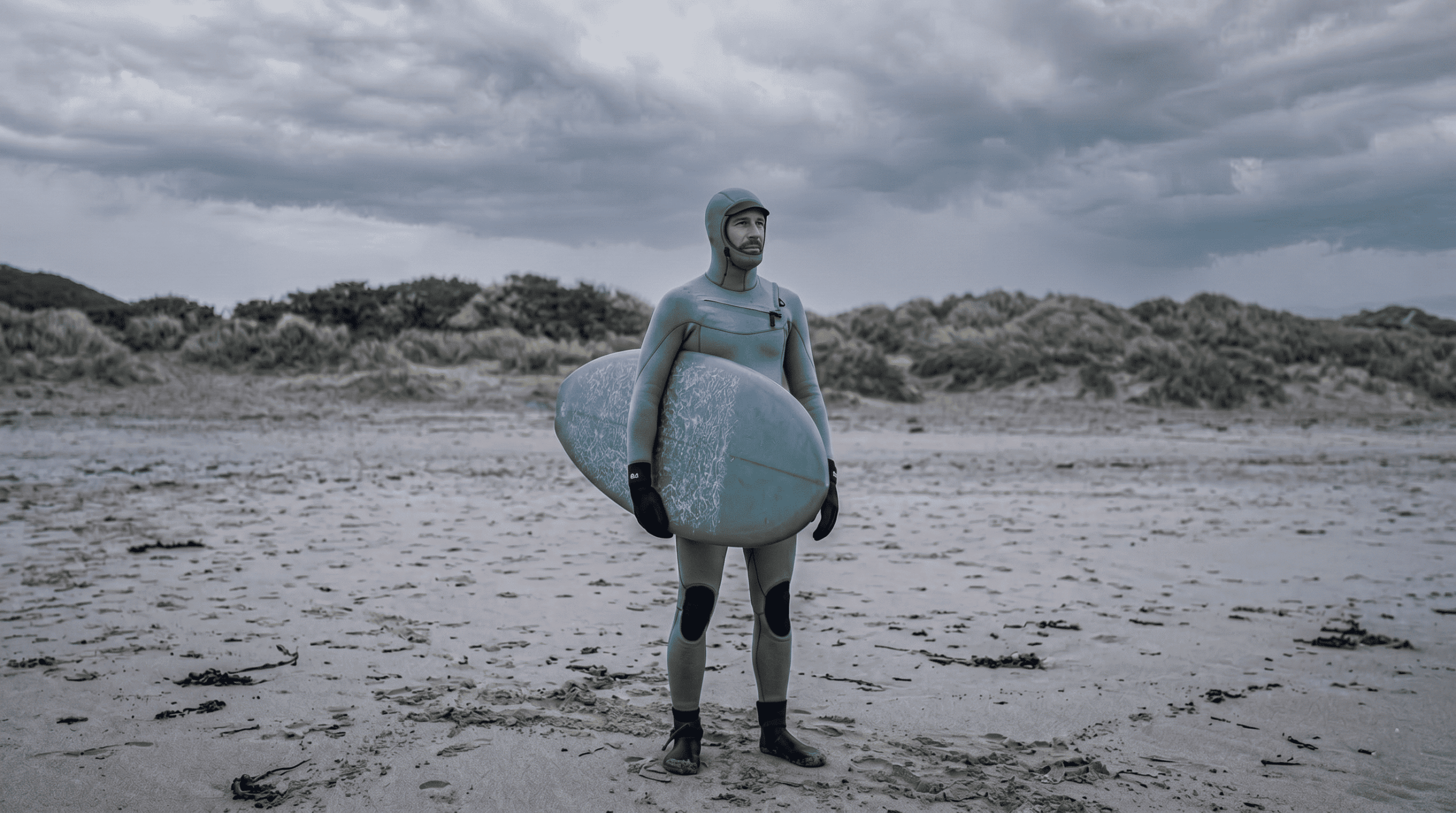 A surfer on the beach on winter